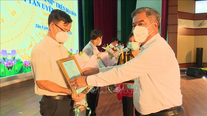 Lãnh đạo thị xã Tân Uyên trao quyết định cho 6 phường, xã chuyển hóa thành “vùng xanh”. Ảnh: TTXVN  