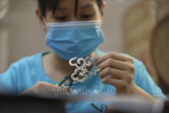 Người công nhân tỉ mỉ, chế tác các chi tiết cho sản phẩm. Ảnh: Minh Quyết - TTXVN
