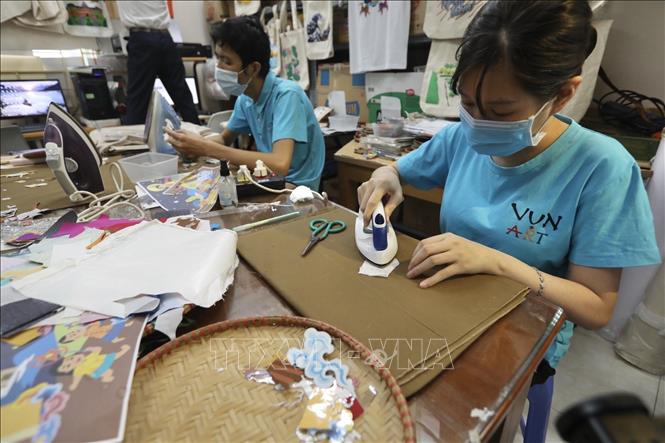 Những công nhân của Vụn Art tỉ mỉ, cần mẫn làm ra những sản phẩm độc đáo phục vụ dịp Tết Trung thu đang đến gần. Ảnh: Minh Quyết - TTXVN