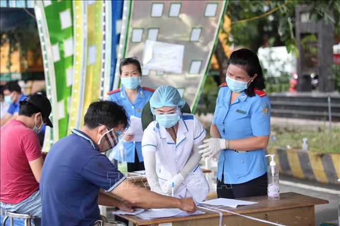 Trong ảnh: Các tài xế khai báo y tế và các thủ tục cần thiết trước khi vào địa phận tỉnh Tây Ninh. Ảnh: Thanh Tân - TTXVN