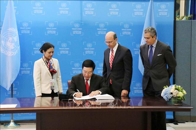 Trong ảnh: Ngày 22/9/2017, tại trụ sở LHQ, New York (Mỹ), thừa ủy quyền của Chủ tịch nước Trần Đại Quang, Phó Thủ tướng, Bộ trưởng Bộ Ngoại giao Phạm Bình Minh ký Hiệp ước Cấm vũ khí hạt nhân. Ảnh: Hữu Hoàng - TTXVN