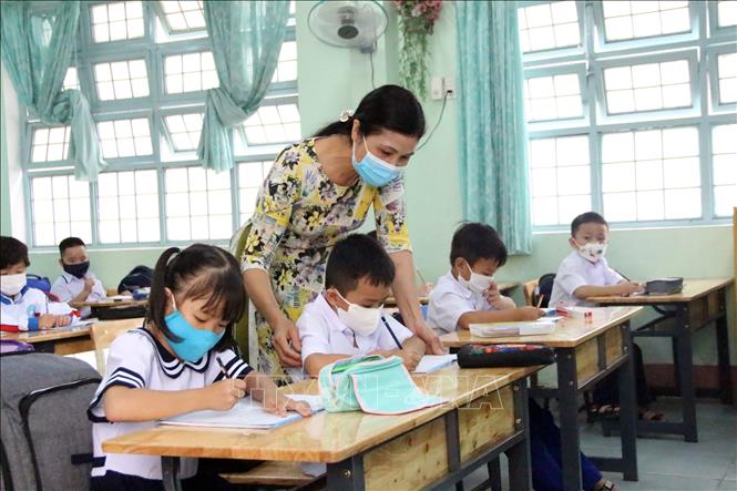 Giáo viên Trường Tiểu học Lê Hồng Phong, thành phố Kon Tum tận tình chỉ bảo các em học sinh lớp 1. Ảnh: Khoa Chương - TTXVN