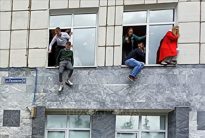 Trong ảnh: Các sinh viên nhảy từ cửa sổ tầng 2 xuống để tìm chỗ trú ẩn khi xảy ra vụ xả súng tại Trường đại học Perm, ngoại ô Moskva, Nga ngày 20/9/2021. Ảnh: AP/TTXVN