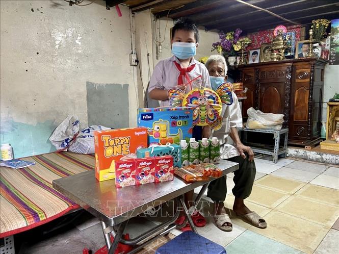 Trong ảnh: Em học sinh có hoàn cảnh khó khăn tại Quận 8, Tp. Hồ Chí Minh vui mừng trước phần quà Trung Thu được tặng. Ảnh: Hồng Giang - TTXVN
