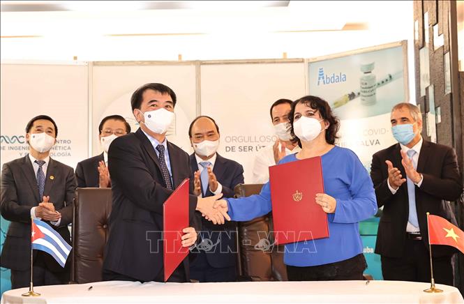 Photo: Vietnamese President Nguyen Xuan Phuc witnesses the signing of cooperation agreement between the two countries. VNA Photo: Thống Nhất