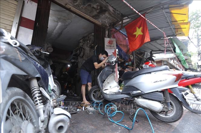 Trong ảnh: Các cửa hàng sửa chữa xe máy được phép hoạt động trở lại. Ảnh: Minh Quyết - TTXVN