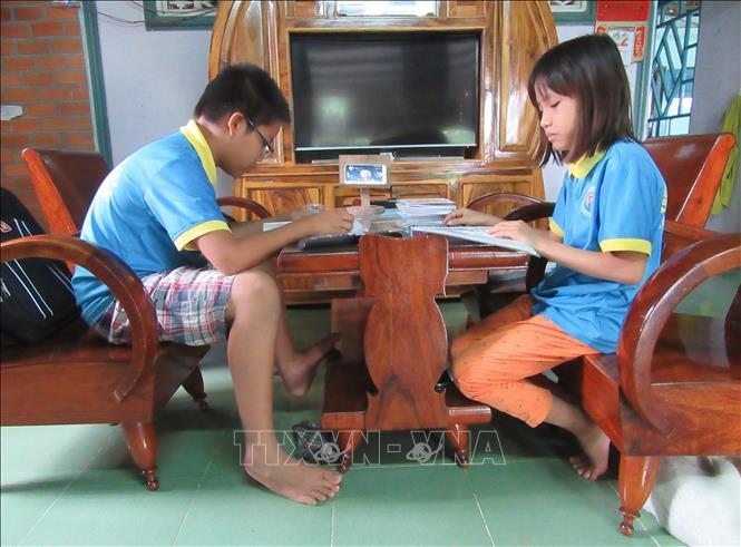 Trong ảnh: Học sinh Trường tiểu học Bình Quý (thị trấn Phước Dân, huyện Ninh Phước) làm bài tập theo hướng dẫn của giáo viên qua chương trình học trực tuyến trên điện thoại thông minh. Ảnh: Nguyễn Thành – TTXVN