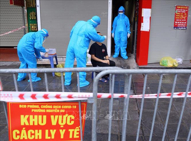 Trong ảnh: Lực lượng y tế phường Nguyễn Du lấy mẫu xét nghiệm cho người dân liên quan đến ca nghi nhiễm số 21 Trần Nhân Tông. Ảnh: Hoàng Hiếu - TTXVN 