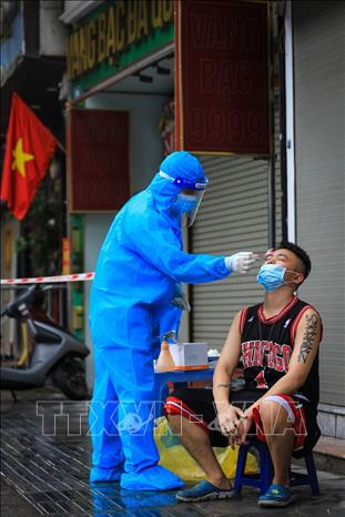 Trong ảnh: Nhân viên y tế phường Nguyễn Du lấy mẫu xét nghiệm cho các hộ dân có liên quan. Ảnh: Thành Đạt - TTXVN 
