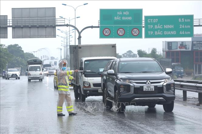 Trong ảnh: Lực lượng chức năng chốt kiểm soát dịch cầu Phù Đổng (huyện Gia Lâm) yêu cầu người tham gia giao thông dừng phương tiện, kiểm tra giấy tờ và khai báo y tế. Ảnh: Minh Quyết - TTXVN