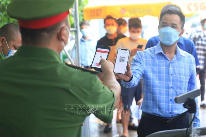 Trong ảnh: Lực lượng công an kiểm tra mã QR của người dân vào Hà Nội tại chốt kiểm soát dịch cầu Phù Đổng. Ảnh: Tuấn Anh - TTXVN