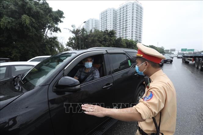 Trong ảnh: Lực lượng chức năng chốt kiểm soát dịch cầu Phù Đổng (huyện Gia Lâm) yêu cầu người tham gia giao thông dừng phương tiện, kiểm tra giấy tờ và khai báo y tế. Ảnh: Minh Quyết - TTXVN