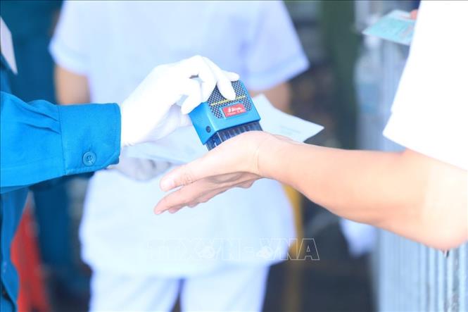 Trong ảnh: Lực lượng chức năng đóng dấu kiểm tra y tế cho người đủ giấy tờ quy định được vào Hà Nội. Ảnh: Tuấn Anh - TTXVN