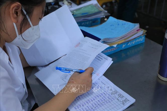 Trong ảnh: Nhân viên y tế kiểm tra giấy tờ và lập danh sách những người vào Hà Nội. Ảnh: Tuấn Anh - TTXVN