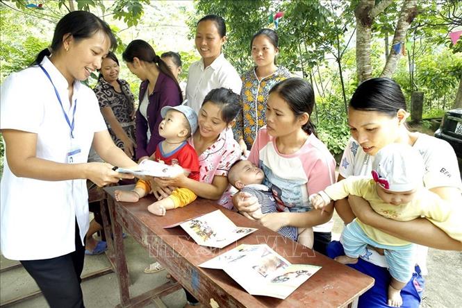 Nhân viên y tế tuyên truyền cho các gia đình đưa trẻ đi tiêm phòng bệnh sởi tại xã Long Phúc - xã vùng sâu, vùng xa của huyện Bảo Yên (Lào Cai). Ảnh: Dương Ngọc – TTXVN