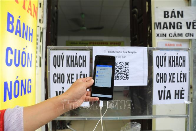 Sau khi quét thành công, màn hình điện thoại sẽ hiện thông tin của người đến mua hàng và tình trạng khai báo y tế. Ảnh: Thành Đạt - TTXVN 
