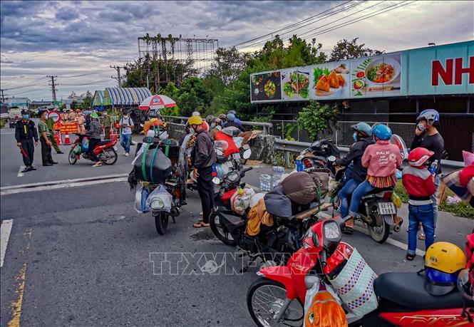 Người dân chạy xe máy về quê bị kẹt giữa cầu số 10 giáp ranh giữa Cần Thơ và Hậu Giang, chiều 25/9. Ảnh: Thanh Liêm - TTXVN