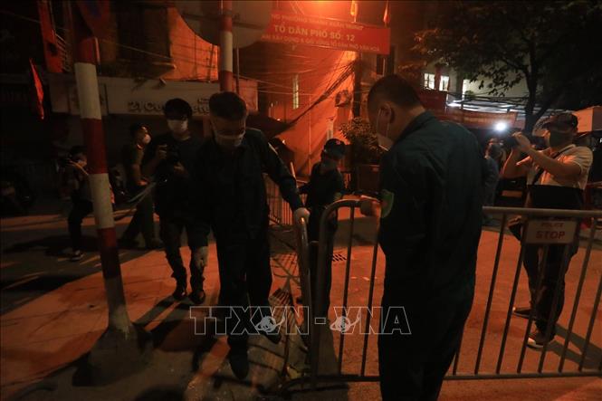 Tromg ảnh: Lực lượng dân quân tự vệ quận Thanh Xuân gỡ bỏ rào chắn tại ngõ 328, 330 đường Nguyễn Trãi. Ảnh: Tuấn Anh - TTXVN