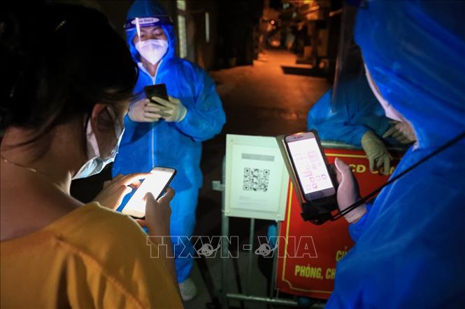 Trong ảnh: Những công dân đầu tiên trở về nhà ngay trong đêm phải quét mã QR-code khai báo y tế. Ảnh: Thành Đạt - TTXVN