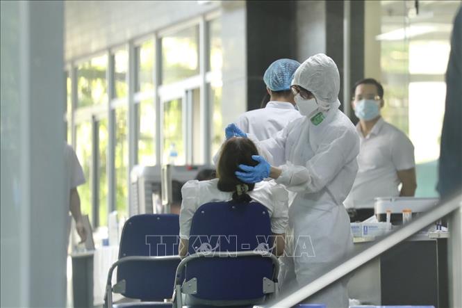 Trong ảnh: Nhân viên y tế lấy mẫu cho người nhà, bệnh nhân, nhân viên y tế trong tòa nhà D Bệnh viện Việt Đức. Ảnh: Minh Quyết - TTXVN