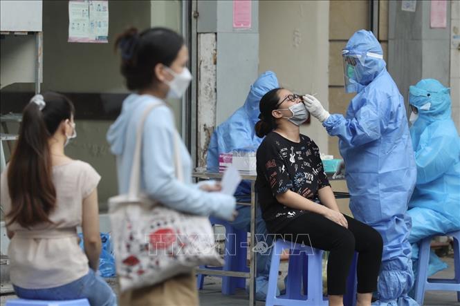 Trong ảnh: Nhân viên y tế lấy mẫu cho người dân bên ngoài cổng Bệnh viện Việt Đức. Ảnh: Minh Quyết - TTXVN