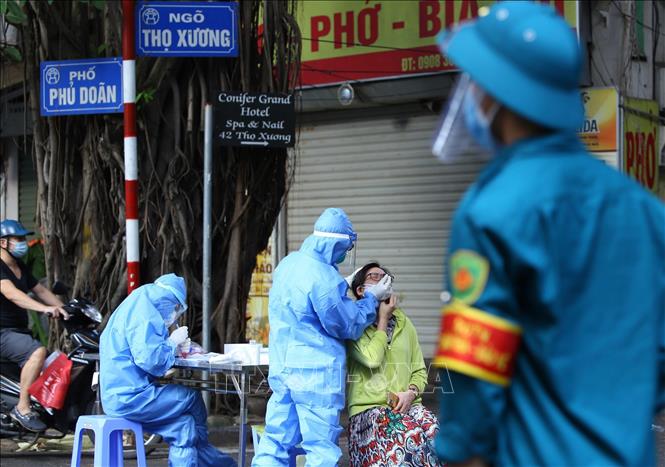 Nhân viên y tế lấy mẫu xét nghiệm cho người dân khu vực lân cận Bệnh viện Việt Đức. Ảnh: Hoàng Hiếu - TTXVN 