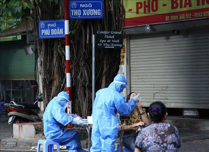 Nhân viên y tế lấy mẫu xét nghiệm cho người dân khu vực lân cận Bệnh viện Việt Đức. Ảnh: Hoàng Hiếu - TTXVN 