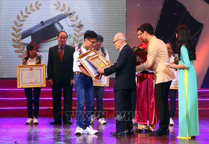 Giáo sư, Anh hùng Lao động Vũ Khiêu trao phần thưởng cho đại diện các học sinh đoạt Huy chương Vàng Olympic quốc tế năm 2014. Ảnh: Quý Trung - TTXVN