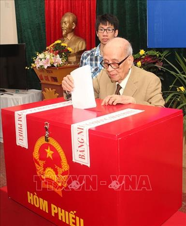 Cử tri cao tuổi nhất, Giáo sư, Anh hùng Lao động Đặng Vũ Khiêu bỏ phiếu bầu cử đại biểu Quốc hội khóa XIV và đại biểu Hội đồng nhân dân các cấp nhiệm kỳ 2016 – 2021, tại khu vực bỏ phiếu số 5, phường Mỹ Đình 2, quận Nam Từ Liêm (Hà Nội). Ảnh: Văn Điệp - TTXVN
