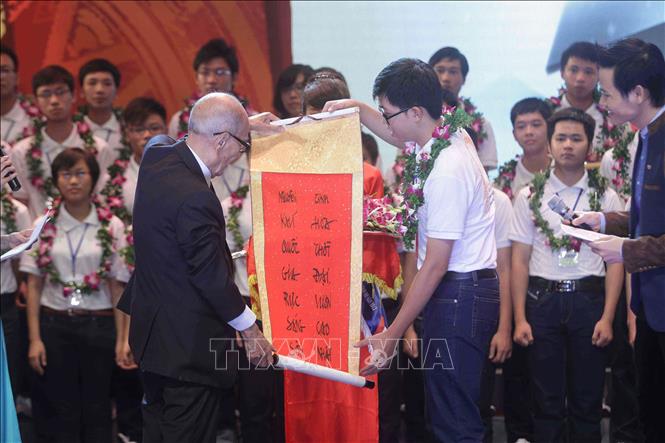 Giáo sư Vũ Khiêu tặng câu đối chúc mừng cho học sinh đoạt giải Olympic Quốc tế và học sinh đạt điểm xuất sắc nhất các khối thi tuyển sinh đại học năm 2013, ngày 2/10/2013, tại Hà Nội. Ảnh: Minh Quyết – TTXVN