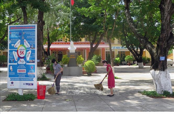 Trong ảnh: Giáo viên Trường THCS Hùng Vương (thành phố Tuy Hòa) dọn dẹp sân trường lớp để chuẩn bị đón học sinh. Ảnh: Xuân Triệu - TTXVN                                 