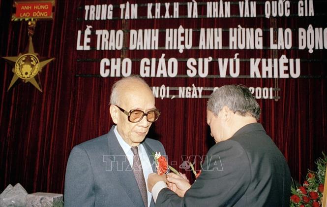 Ngày 2/1/2001, tại Hà Nội, Trung tâm Khoa học xã hội và Nhân văn quốc gia tổ chức lễ trao tặng danh hiệu Anh hùng Lao động thời kỳ đổi mới cho Giáo sư Vũ Khiêu. Trong ảnh: Chủ nhiệm Văn phòng Quốc hội Vũ Mão gắn huy hiệu Anh hùng Lao động thời kỳ đổi mới cho Giáo sư Vũ Khiêu. Ảnh: Nhan Sáng - TTXVN
