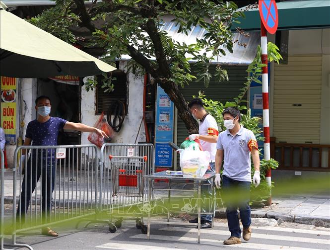 Trong ảnh: Vận chuyển hàng hoá tiếp tế vào cho người dân trong khu vực bị phong tỏa phố Phủ Doãn. Ảnh: Hoàng Hiếu - TTXVN 