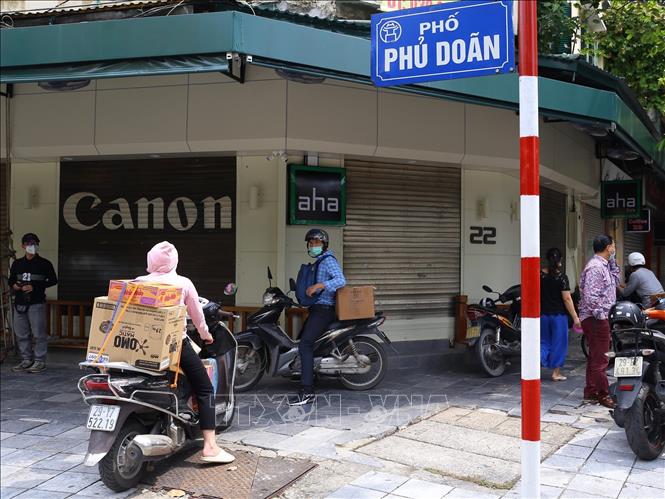 Trong ảnh: Nhiều người dân chờ đưa đồ tiếp tế vào khu vực bị phong tỏa phố Phủ Doãn (ảnh chụp sáng 2/10). Ảnh: Hoàng Hiếu - TTXVN 