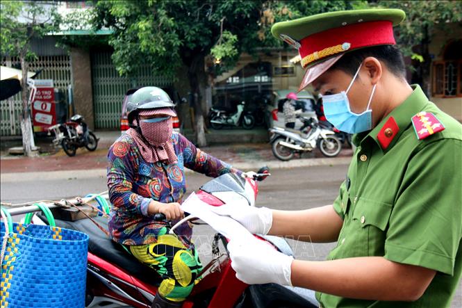 Trong ảnh: Người dân đi lại giữa các khu vực áp dụng Chỉ thị 16 phải có giấy tờ để trình kiểm soát theo quy định. Ảnh: Nguyễn Thanh - TTXVN