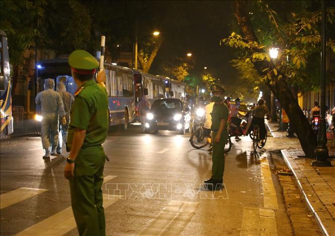 Trong ảnh: Lực lượng chức năng quận Hoàn Kiếm tạm dừng giao thông phố Tràng Thi khi xe đưa người bệnh đi chuyển khỏi Bệnh viện hữu nghị Việt Đức. Ảnh: Hoàng Hiếu - TTXVN 
