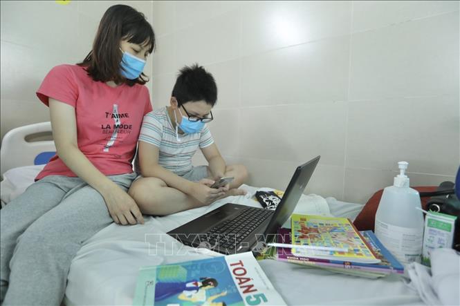 Trong ảnh: Có trường hợp bệnh nhi phải sử dụng máy tính, điện thoại học online ngay tại bệnh viện. Ảnh: Minh Quyết - TTXVN