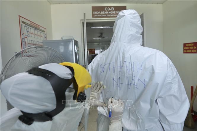 Trong ảnh: Các bác sĩ, điều dưỡng khi vào khu cách ly dành cho bệnh nhân và người nhà bệnh nhân chuyển đến từ bệnh viện Việt Đức trang bị bảo hộ kỹ lưỡng. Ảnh: Minh Quyết - TTXVN