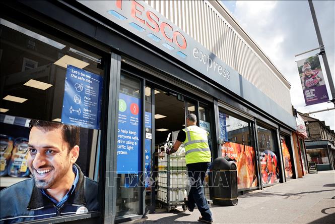 Trong ảnh: Công nhân chuyển hàng hóa tại một siêu thị của Tesco ở thủ đô London, Anh, ngày 3/8/2021. Ảnh: AFP/TTXVN
