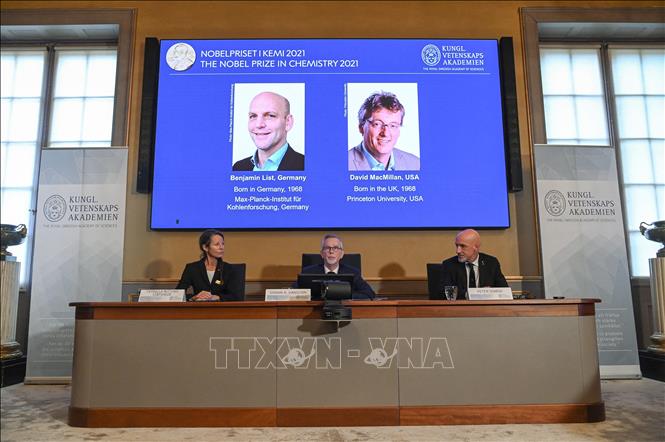 Trong ảnh: Chân dung hai nhà khoa học được vinh danh với giải Nobel Hóa học 2021 (từ trái sang, trên màn hình): Benjamin List (người Đức) và David MacMillan (người Mỹ), tại lễ công bố giải thưởng ở Viện Hàn lâm khoa học Hoàng gia Thụy Điển, tại Stockholm, ngày 6/10/2021. Ảnh: AFP/TTXVN