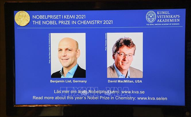 Trong ảnh: Chân dung hai nhà khoa học được vinh danh với giải Nobel Hóa học 2021 (từ trái sang, trên màn hình): Benjamin List (người Đức) và David MacMillan (người Mỹ), tại lễ công bố giải thưởng ở Viện Hàn lâm khoa học Hoàng gia Thụy Điển, tại Stockholm, ngày 6/10/2021. Ảnh: AFP/TTXVN