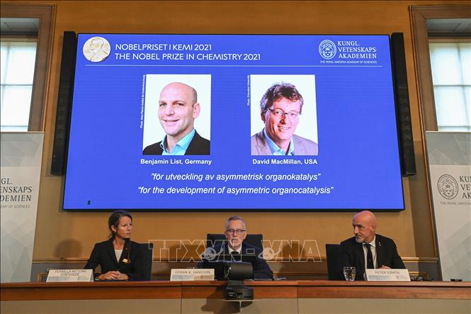 Trong ảnh: Chân dung hai nhà khoa học được vinh danh với giải Nobel Hóa học 2021 (từ trái sang, trên màn hình): Benjamin List (người Đức) và David MacMillan (người Mỹ), tại lễ công bố giải thưởng ở Viện Hàn lâm khoa học Hoàng gia Thụy Điển, tại Stockholm, ngày 6/10/2021. Ảnh: AFP/TTXVN