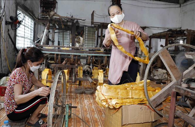 Bà Phan Thị Thuận thường xuyên kiểm tra, hướng dẫn người lao động ở xưởng kéo sợi. Ảnh: Trần Việt - TTXVN