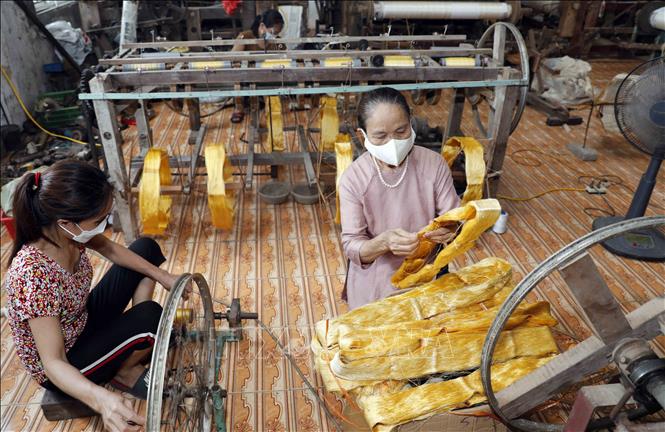 Bà Phan Thị Thuận thường xuyên kiểm tra, hướng dẫn người lao động ở xưởng kéo sợi. Ảnh: Trần Việt - TTXVN