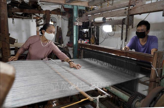 Ngoài việc quản lý, bà Phan Thị Thuận thường xuyên kiểm tra, hướng dẫn người lao động ở xưởng dệt. Ảnh: Trần Việt - TTXVN