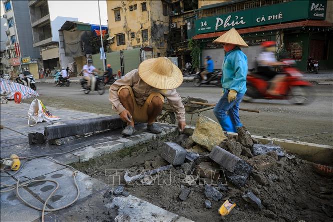 Trong ảnh: Thời điểm hiện tại, đơn vị thi công đang đẩy nhanh những công đoạn hoàn thiện hệ thống cấp thoát nước, thi công lớp móng đường cấp phối đá dăm, phần vỉa hè cho người đi bộ... Ảnh: Thành Đạt - TTXVN