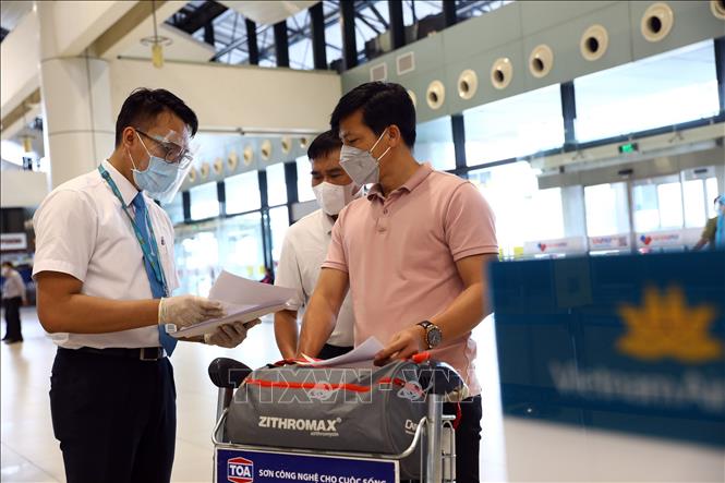 Nhân viên của Vietnam Airlines kiểm tra giấy tờ của hành khách trước khi vào làm thủ tục. Ảnh: Huy Hùng – TTXVN