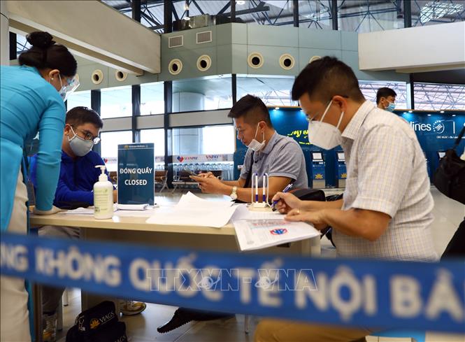 Trước khi vào làm thủ tục, hành khách phải thực hiện khai báo y tế và ký bản cam kết phòng chống dịch COVID-19. Ảnh: Huy Hùng – TTXVN