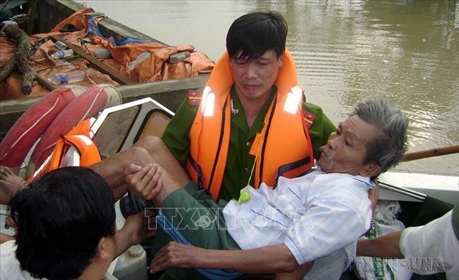 Chiến sĩ Công an Hà Tĩnh giải cứu người già xã Thuận Lộc, thị xã Hồng Lĩnh ra khỏi vùng ngập lụt. Ảnh: Duy Khương – TTXVN