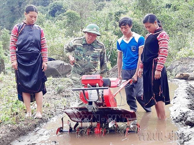 Chiến sĩ Bộ đội Biên phòng Lai Châu hướng dẫn đồng bào dân tộc sử dụng máy cày làm đất để trồng lúa nước. Ảnh: Công Tuyên - TTXVN